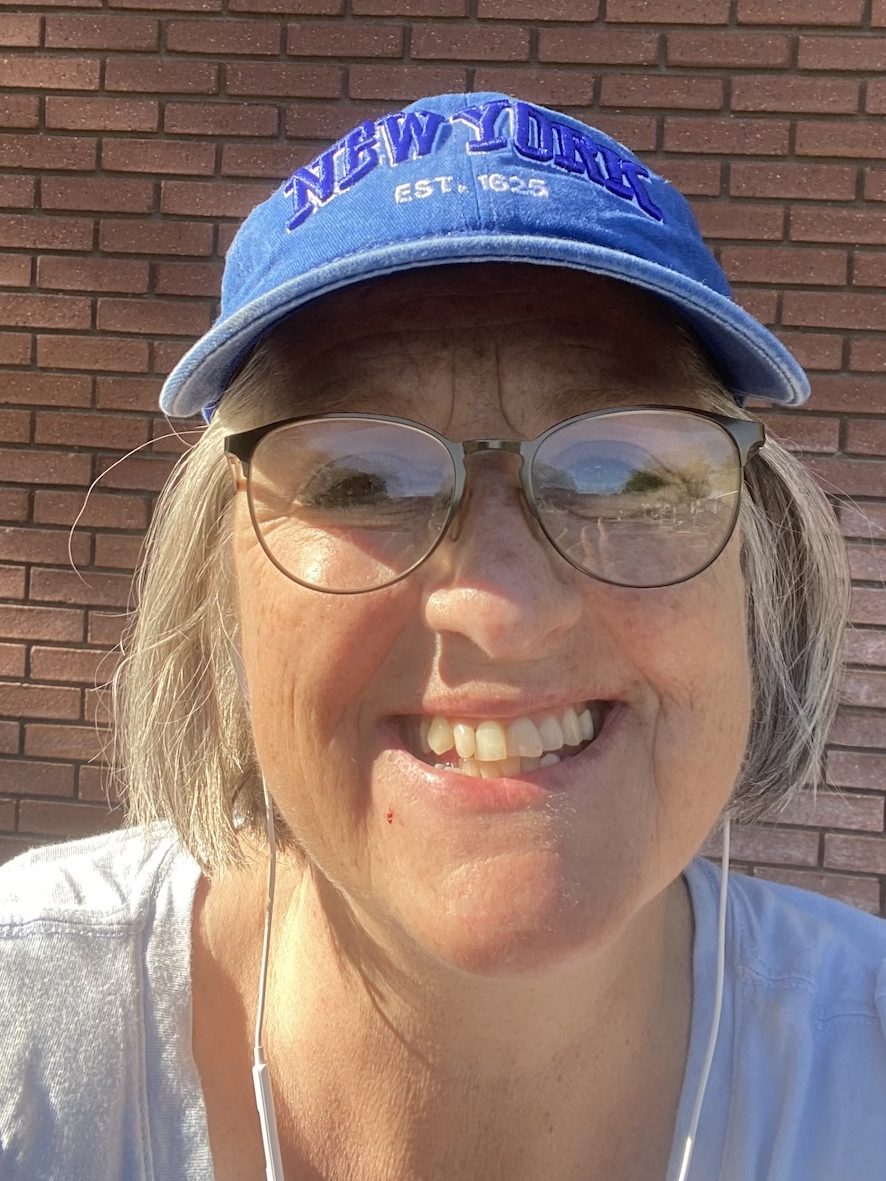 Shelley Canalia of Stages Planning Group, wearing a cap and earbuds and smiling